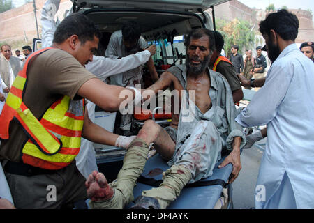 Bomba Blast vittime della strada Charsadda vengono spostate alla Signora Lettura in ospedale per il trattamento, nella città di Peshawar Venerdì, 27 settembre 2013. Circa 19 persone sono state uccise e 44 altri subito lesioni in un'esplosione all'interno di un bus sulla strada Charsadda. L'attacco mirato un bus del segretariato civile dipendenti che stava trasportando circa 60 persone. La bomba è stata collocata nella parte posteriore del bus. Secondo l'eliminazione della bomba squad (BDS), la bomba conteneva circa sei o sette chilogrammi di materiale esplosivo e aveva un dispositivo temporizzato ad esso collegato. L'esplosione è stata così ho... Foto Stock