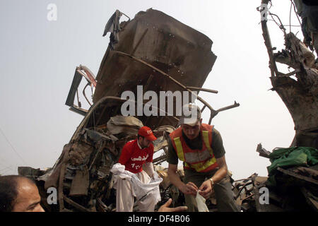 Recuse funzionari impegnati in lavoro recuse presso il sito dopo un'esplosione all'interno di un bus sulla strada Charsadda nella città di Peshawar Venerdì, 27 settembre 2013. Circa 19 persone sono state uccise e 44 altri subito lesioni in un'esplosione all'interno di un bus sulla strada Charsadda. L'attacco mirato un bus del segretariato civile dipendenti che stava trasportando circa 60 persone. La bomba è stata collocata nella parte posteriore del bus. Secondo l'eliminazione della bomba squad (BDS), la bomba conteneva circa sei o sette chilogrammi di materiale esplosivo e aveva un dispositivo temporizzato ad esso collegato. L'esplosione è stata ... Foto Stock