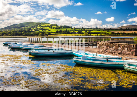 Barche a remi ormeggiate a Llangors Lake nel Parco Nazionale di Brecon Beacons, Galles. Foto Stock