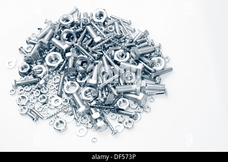 Pila di dadi e bulloni su sfondo semplice Foto Stock