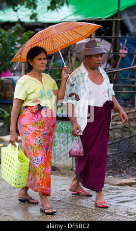 La gente a piedi nei pressi di una stazione ferroviaria a Yangon, Birmania. Foto Stock