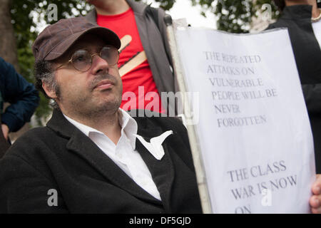 Londra, Regno Unito. Il 28 settembre, 2013. Un manifestante ascolta per altoparlanti come persone disabili contro i tagli e i loro sostenitori tenere una manifestazione di protesta a Londra in piazza del Parlamento contro il lavoro Capabilty valutazione effettuata sul contratto da ATOS. Credito: Paolo Davey/Alamy Live News Foto Stock