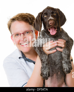 Donna felice e tedesco puntatore wirehaired puppy, dodici settimane, sfondo bianco Foto Stock