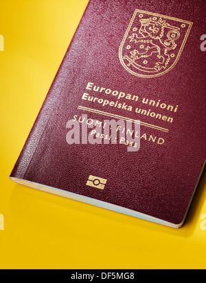 Finlandese (Finlandia) passaporto su sfondo giallo. Questa è la nuova (2013) design del passaporto Foto Stock