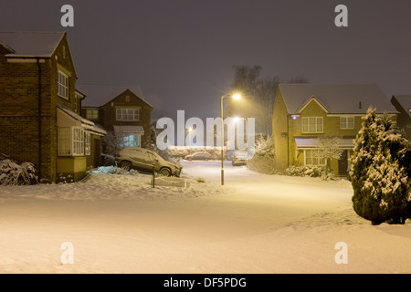 Raggiera luce dalle lampade steet notturno illumina privato case moderne in freddo, coperta di neve cul-de-sac - Burley in Wharfedale, Inghilterra, Regno Unito. Foto Stock