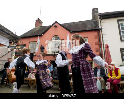 Llandovery, Galles, Regno Unito. Sabato 28 settembre 2013. I bambini di Menter Bro Dinefwr eseguono danze tradizionali popolari gallesi nella piazza del mercato al Llandovery Sheep Festival, che celebra tutti gli aspetti della produzione di pecore e lana. Le ragazze indossano abiti in tessuto gallese realizzati al Melin Tregwynt Woollen Mill. KATHY DEWITT/Alamy Live News Foto Stock