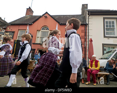 Llandovery, Galles, Regno Unito. Sabato 28 settembre 2013. I bambini di Menter Bro Dinefwr eseguono danze tradizionali popolari gallesi nella piazza del mercato al Llandovery Sheep Festival, che celebra tutti gli aspetti della produzione di pecore e lana. Le ragazze indossano abiti in tessuto gallese realizzati al Melin Tregwynt Woollen Mill. KATHY DEWITT/Alamy Live News Foto Stock