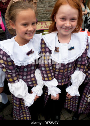 Llandovery, Wales, Regno Unito. Sabato 28 settembre 2013. Bambini da Menter Bro Dinefwr eseguire Welsh tradizionali danze popolari in Piazza del Mercato a Llandovery pecore Festival che celebra tutti gli aspetti di ovini e la produzione della lana. Le ragazze indossare abiti di Welsh tessuto costituito presso la Melin Tregwynt Lanificio. KATHY DEWITT/Alamy Live News Foto Stock