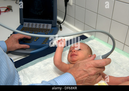 Medico usando un Fujifilm SonoSite MicroMaxx portable macchina ad ultrasuoni per esaminare un battito del cuore del bambino Foto Stock