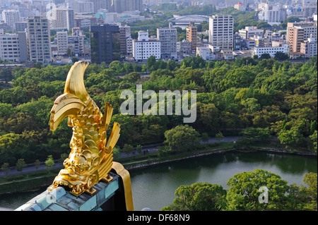 Vista dal piano superiore del castello di Osaka con il parco e di business nel settore della città e un pesce dorato. Foto Stock