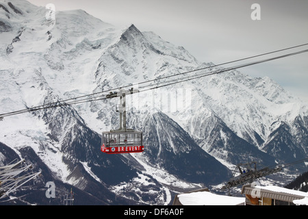 Cavo rosso vettura contro la montagna innevata sullo sfondo. Foto Stock