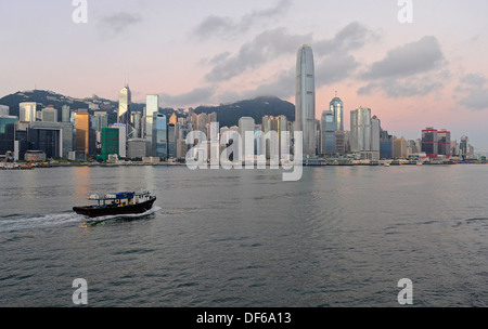 Skyline di Hong Kong all'alba con piccole barche da pesca. Foto Stock