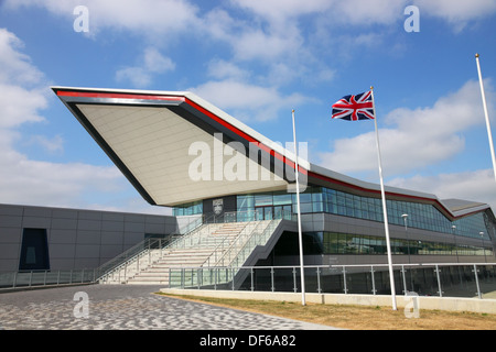 L'ala costruzione presso il circuito di Silverstone con Union Jack flag battenti contro un cielo blu. Foto Stock