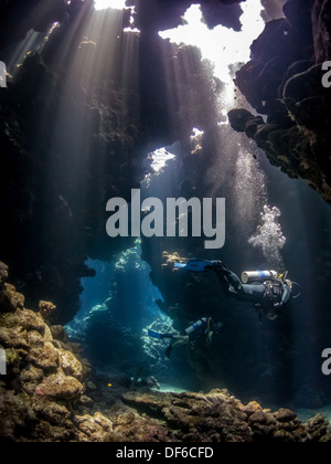 Persone Scuba diving nella bellissima swimthroughs di Sha'ab Claudio, Egitto Foto Stock