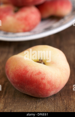 Ciambella Pesche noto anche come Saturno pesche su un tavolo rustico. Foto Stock