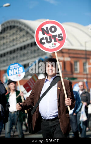 Manchester, Regno Unito. 29 settembre 2013. Un uomo sulla quarantina holding aloft un segno a leggere 'n' tagli durante un Nord Ovest TUC marzo organizzata e rally che intendono difendere il servizio sanitario nazionale (NHS) i posti di lavoro e servizi da tagli e privatizzazione. Il mese di marzo coincide con il Congresso del Partito Conservatore 2013 che si terrà nella città. Credito: Russell Hart/Alamy Live News. Foto Stock