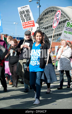 Manchester, Regno Unito. 29 settembre 2013. Una donna nel suo ventenne holding aloft un segno durante un Nord Ovest TUC marzo organizzata e rally che intendono difendere il servizio sanitario nazionale (NHS) i posti di lavoro e servizi da tagli e privatizzazione. Il mese di marzo coincide con il Congresso del Partito Conservatore 2013 che si terrà nella città. Credito: Russell Hart/Alamy Live News. Foto Stock