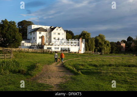 Una coppia di mezz'età camminando loro Airedale Terrier cane lungo un sentiero sul prato Fullingpit a Sudbury, Suffolk, Regno Unito. Foto Stock