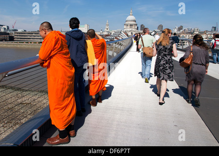 I monaci buddisti sul Millennium Bridge con la Cattedrale di St Paul in background, Londra, Inghilterra, Regno Unito. Foto Stock