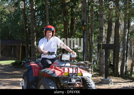 Giovane uomo a cavallo di un Quad in Quebec strada rurale, Canada Foto Stock