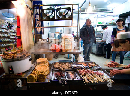 Un cibo di strada in stallo la vibrante street market alimentare in Xian il Quartiere Musulmano. Foto Stock
