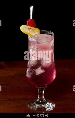 Limonata al lampone servita in un calice su una barra scura Foto Stock