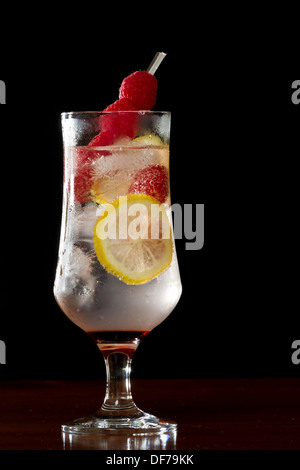 Limonata al lampone servita in un calice su una barra scura Foto Stock