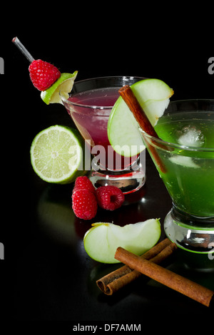 Autunno rinfrescanti cocktail guarnita con frutta fresca isolata su uno sfondo nero Foto Stock