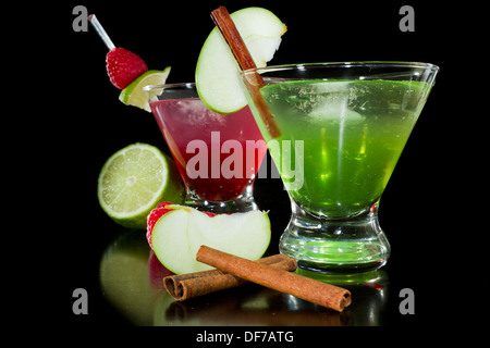 Autunno rinfrescanti cocktail guarnita con frutta fresca isolata su uno sfondo nero Foto Stock