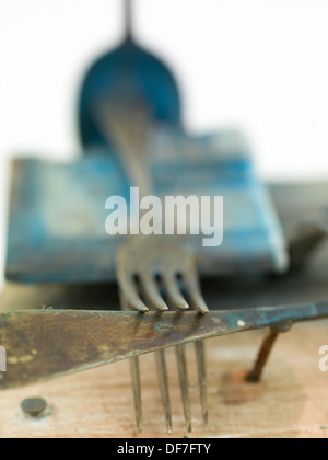 Macro di un vecchio arrugginito forcella disposta su altri pezzi di metallo e legno Foto Stock