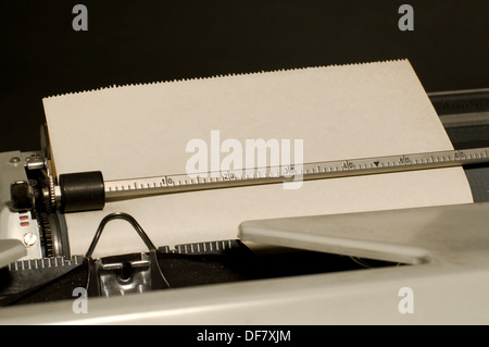 Macchina da scrivere Vintage con foglio di carta interno su sfondo nero Foto Stock
