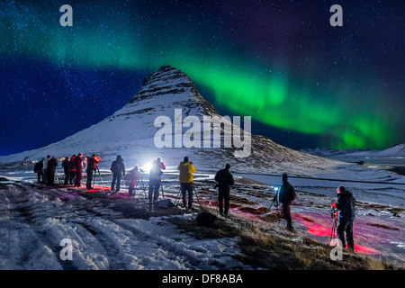 La gente che prende le immagini delle aurore boreali o luci del nord oltre mt Kirkjufell, Snaefellsnes Peninsula, Islanda Foto Stock