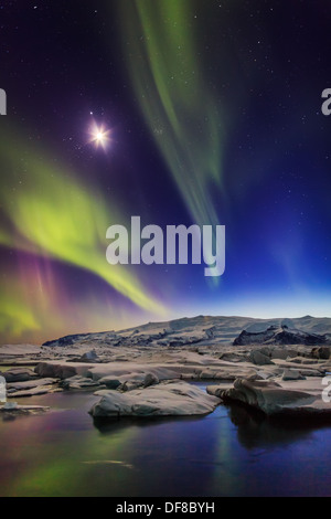 Luna con l'Aurora Boreale o luci del nord a Jokulsarlon, Breidamerkurjokull, Vatnajokull calotta di ghiaccio, Islanda. Foto Stock