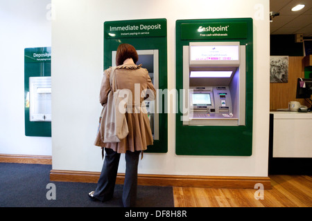 Un cliente che utilizza il nuovo deposito di immediata capacità, interno della Lloyds Bank, il concetto di tecnologia moderna in banche, REGNO UNITO Foto Stock