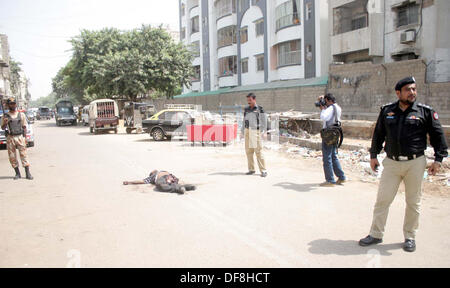 I funzionari di sicurezza raccogliere vicino al corpo morto di dacoits (bandit) che si è fatto esplodere con una bomba a mano durante la polizia incontro al soldato area Bazar di Karachi il lunedì, 30 settembre 2013. Foto Stock