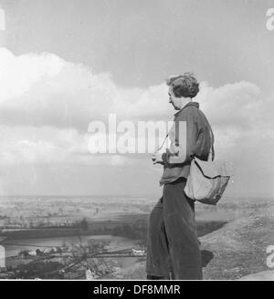 Quadro storico,anni cinquanta di una femmina con back pack guardando la vista dalla sulla cima di una collina nel distretto del lago, Inghilterra. Foto Stock