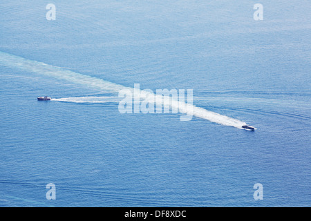 Intersezione di due barche di potenza nell'oceano con il puntello lungo linee di lavaggio Foto Stock