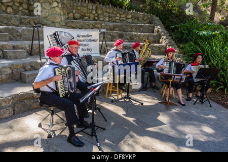 La fisarmonica della società musicale internazionale a giocare al di fuori e indossano berretti rossi a Santa Barbara, California. Foto Stock