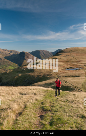 Walker su Whin Rigg nel Lake District inglese, con testa Illgill in background Foto Stock