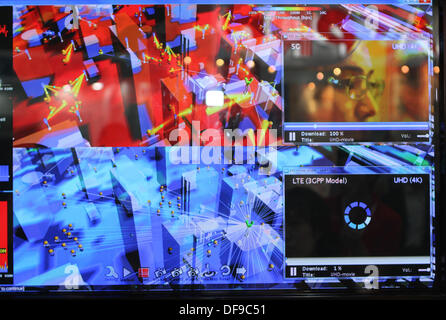 Tokyo, Giappone. 01 ott 2013. Giapponese di telefonia mobile operatore NTT DoCoMo presenta un nuovo monile telefono di rete al consumer electronics fiera CEATEC 2013 presso il centro congressi Makuhari Messe a Chiba vicino a Tokyo, Giappone, 01 ottobre 2013. Il 5G network è supposto per essere cento volte più veloce di LTE e essere in grado di gestire una mille volte più grande del volume dei dati. È programmata per essere in funzionamento in tempo per i Giochi Olimpici Estivi 2020 a Tokyo. La simulazione mostra %G service di Shinjuku in rosso e un netwrok LTE in blu. Foto: Christoph Dernbach/dpa/Alamy Live News Foto Stock