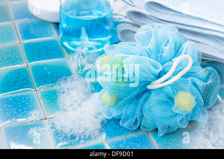 Soft bagno blu puff o spugna blu su sfondo piastrelle Foto Stock