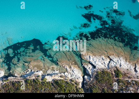 VISTA AEREA VERTICALE. Acque cristalline della costa rocciosa al Désert des Agriates vicino alla città di Saint-Florent, Corsica, Francia. Foto Stock