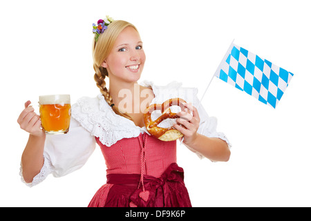 Felice giovane donna in dirndl con birra e pretzel e una bandiera bavarese Foto Stock