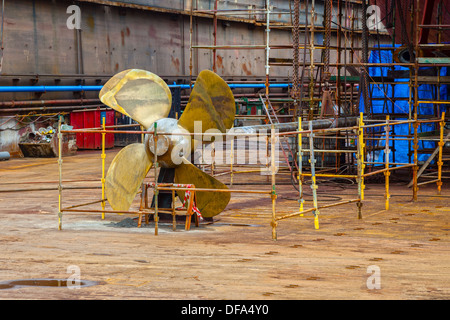 L'elica di una nave in un bacino a secco in fase di preparazione per i lavori di manutenzione. Foto Stock
