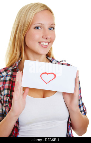 Giovane donna bionda in possesso di una lettera d'amore con cuore rosso Foto Stock