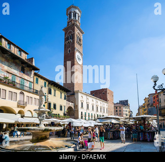 Le bancarelle del mercato in Piazza delle Erbe che guarda verso la Torre dei Lamberti, Verona, Veneto, Italia Foto Stock