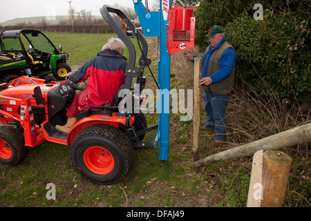 Un post perforatore macine in azione la creazione di una recinzione REGNO UNITO Foto Stock