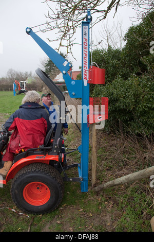 Un post perforatore macine in azione la creazione di una recinzione REGNO UNITO Foto Stock