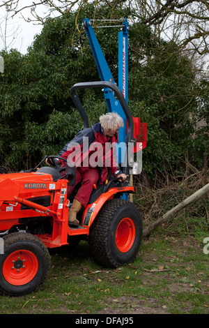 Un post perforatore macine in azione la creazione di una recinzione REGNO UNITO Foto Stock