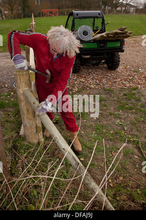 Un post perforatore macine in azione la creazione di una recinzione REGNO UNITO Foto Stock